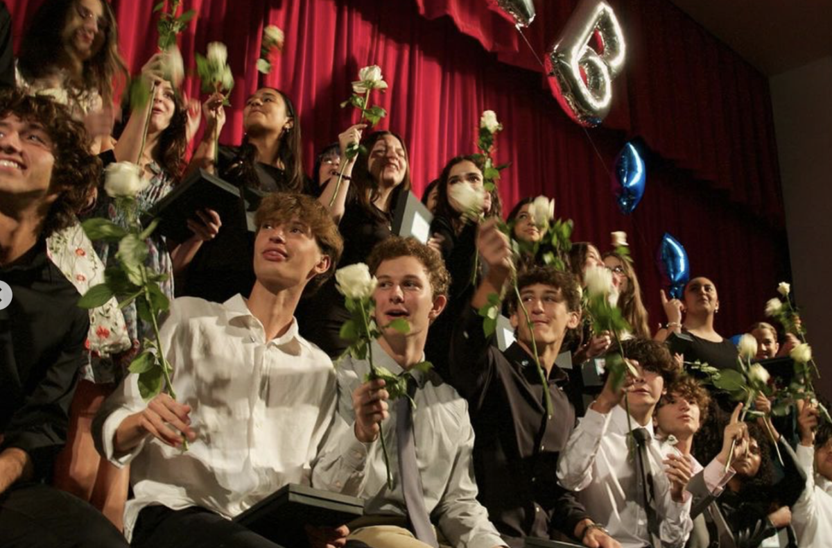 Posing for their class picture, juniors take a minute to sway their roses in unison, a silent promise to their pledge into the IB program. 